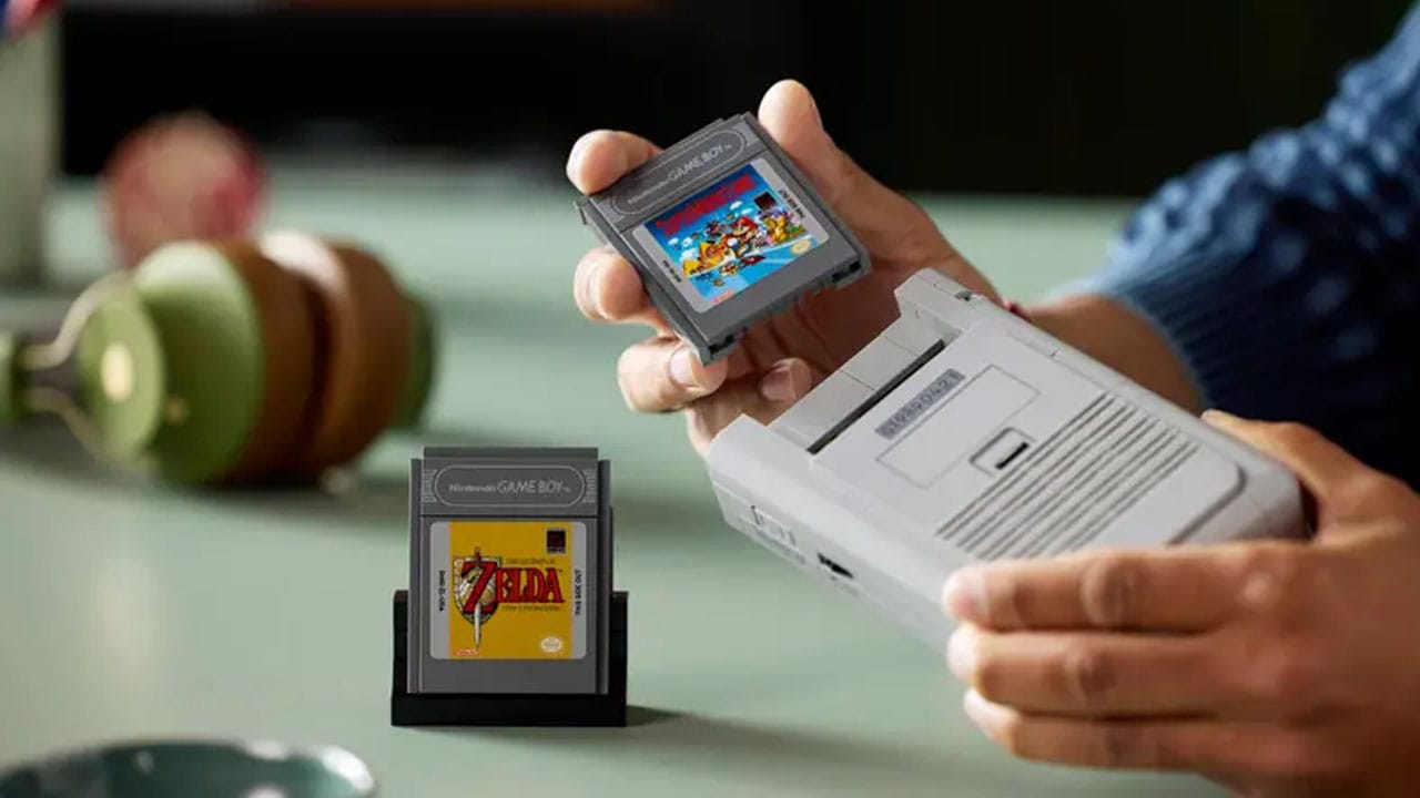 A man about to put a LEGO game cartridge into the LEGO Game Boy
