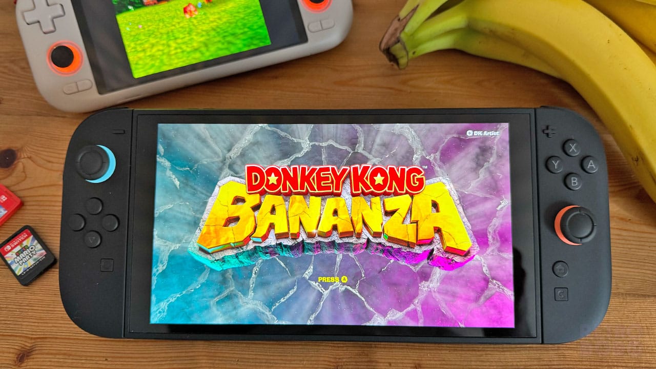 Donkey Kong Bananza on the Switch 2 next to some bananas. Another handheld is showing DK64 gameplay