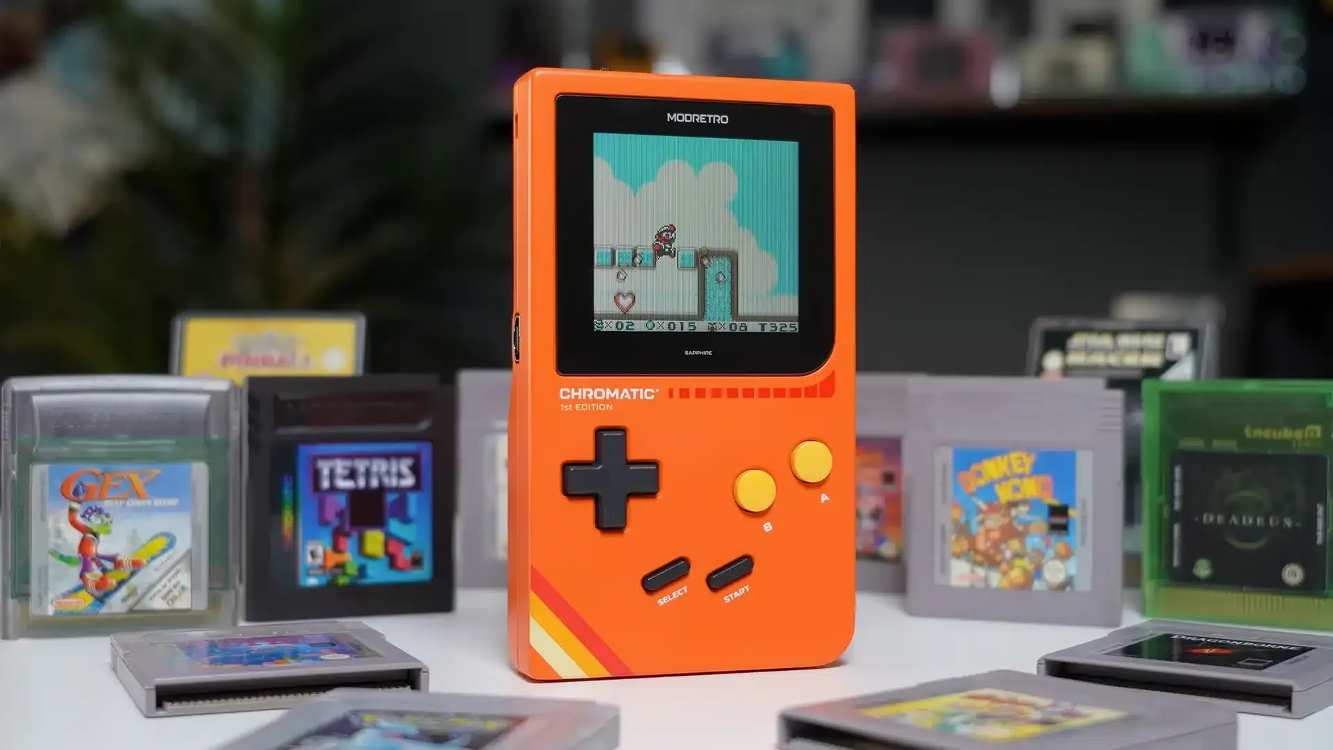 Brandon's ModRetro Chromatic (orange) surrounded by games