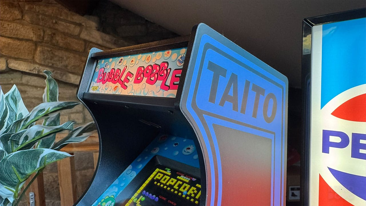 close up of the Bubble Bobble front panel and the Taito branding on the Quarter Arcades cabinet