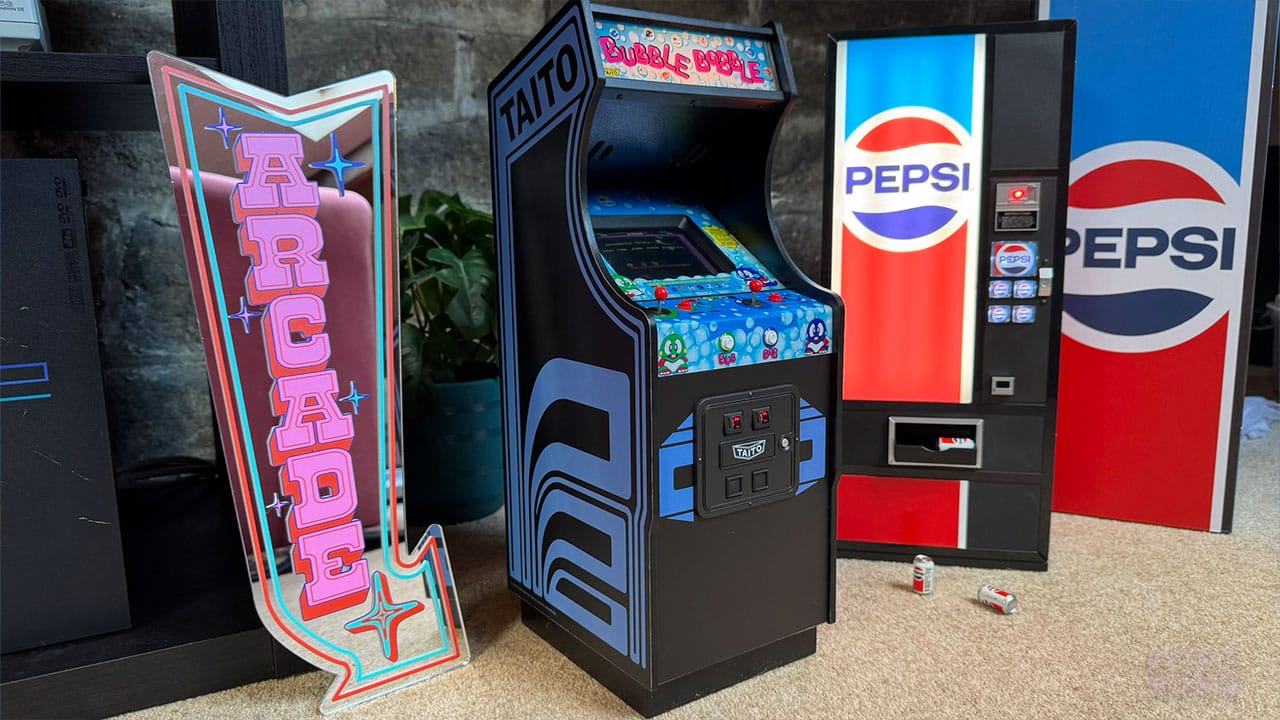 Quarter Arcades products with an Arcade sign mirror beside them. There are two miniature Pepsi cans on the floor and one in the drinks tray