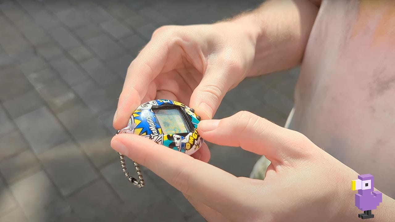 The History Of Tamagotchi - Rob holding a Tamagotchi