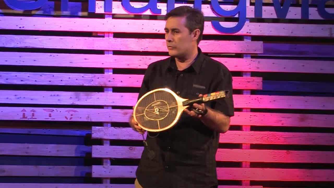 Tom at a ted talk with his bug-zapper guitar