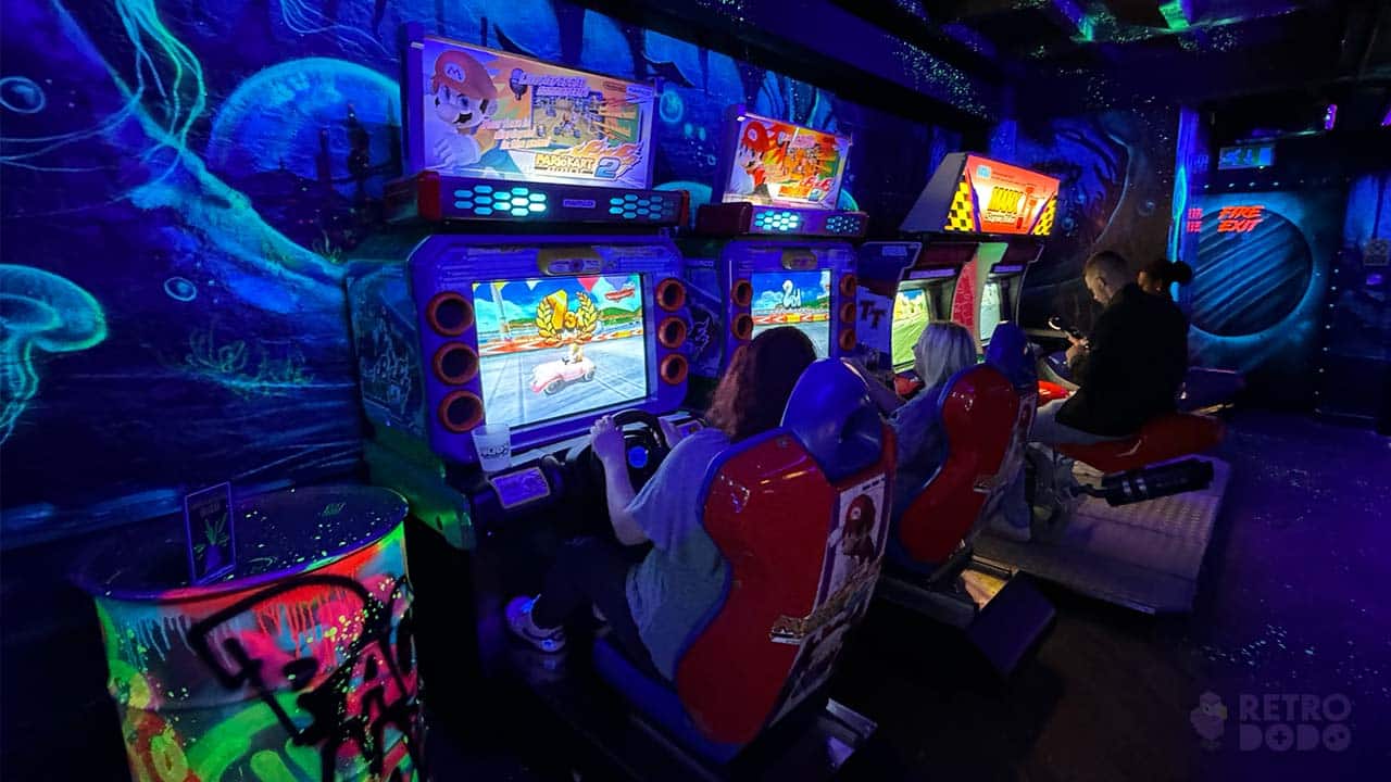 People sat playing on Mario Kart and Bike arcade games