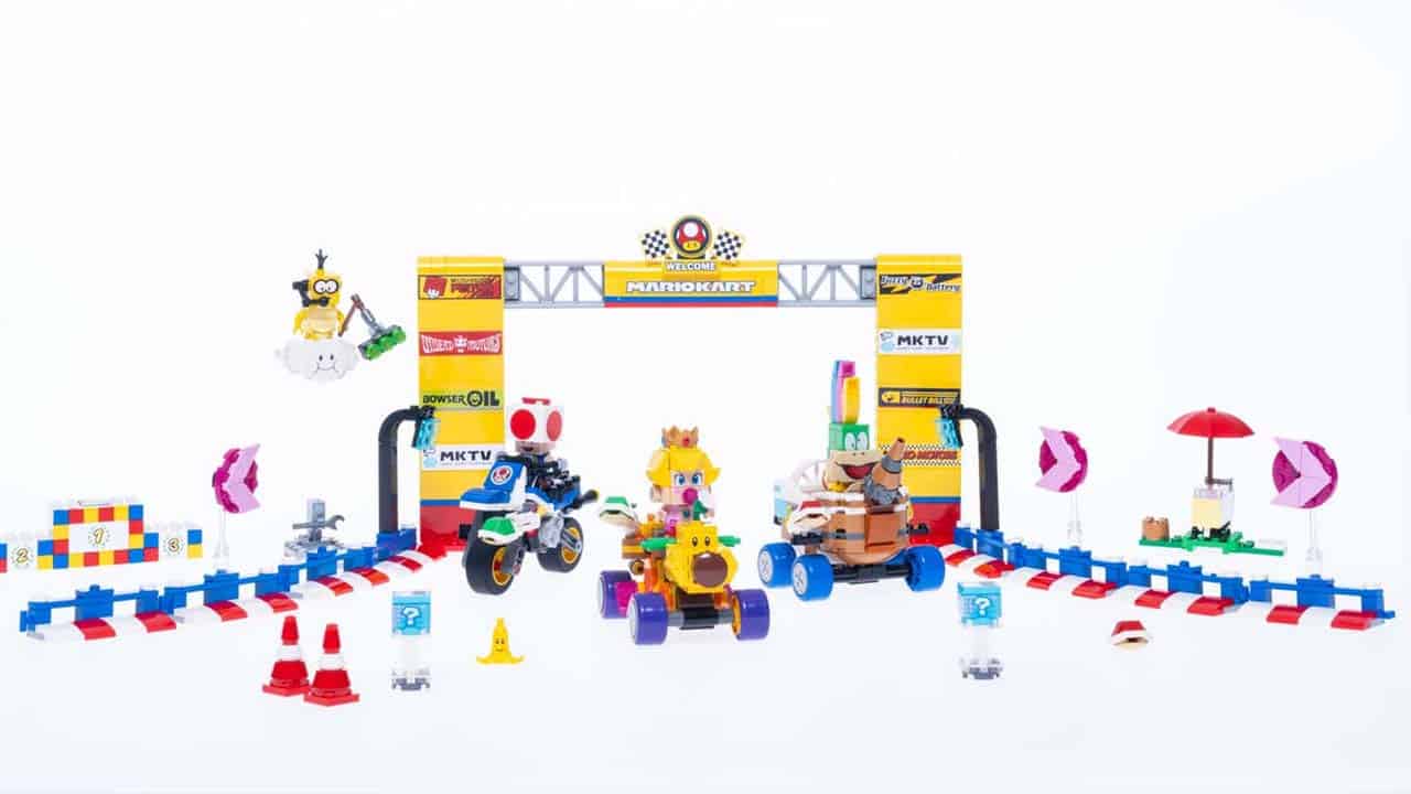 Baby Peach on a Wiggler, Toad on a Bike, and Lemmy on the Landship Lart in a LEGO recreation of the Mario Kart start line