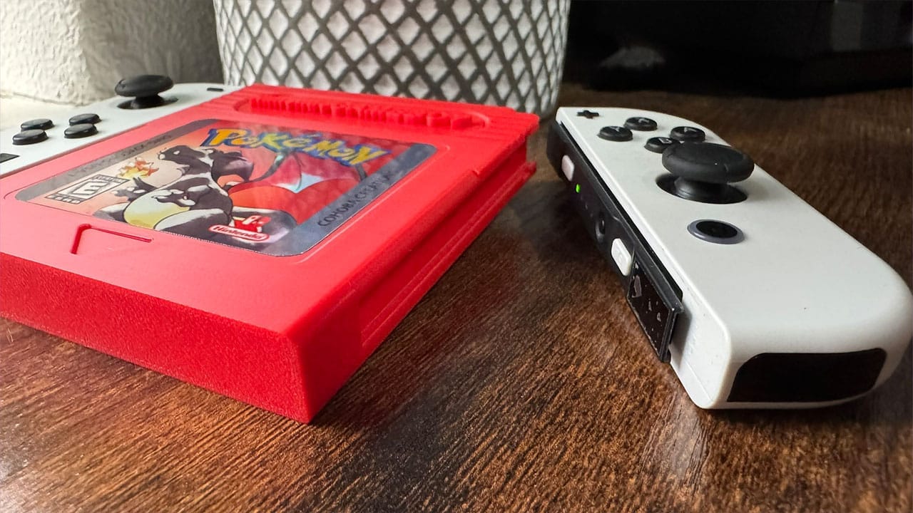 A joycon sitting next to a large version of Pokémon Red