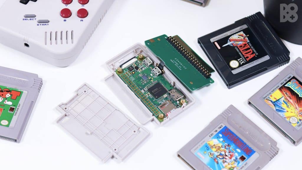 Gameboy games on a table and a housing unit for a raspberry pi circuit board