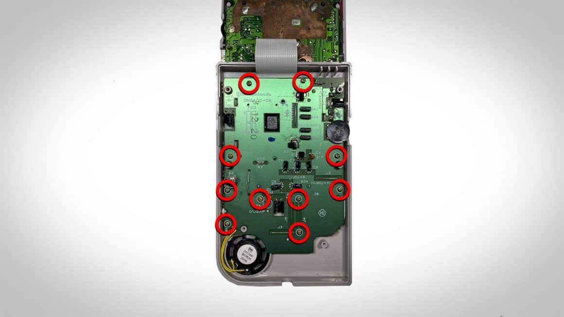 Circles showing where to unscrew the face plate of a Gameboy once the case has been taken off
