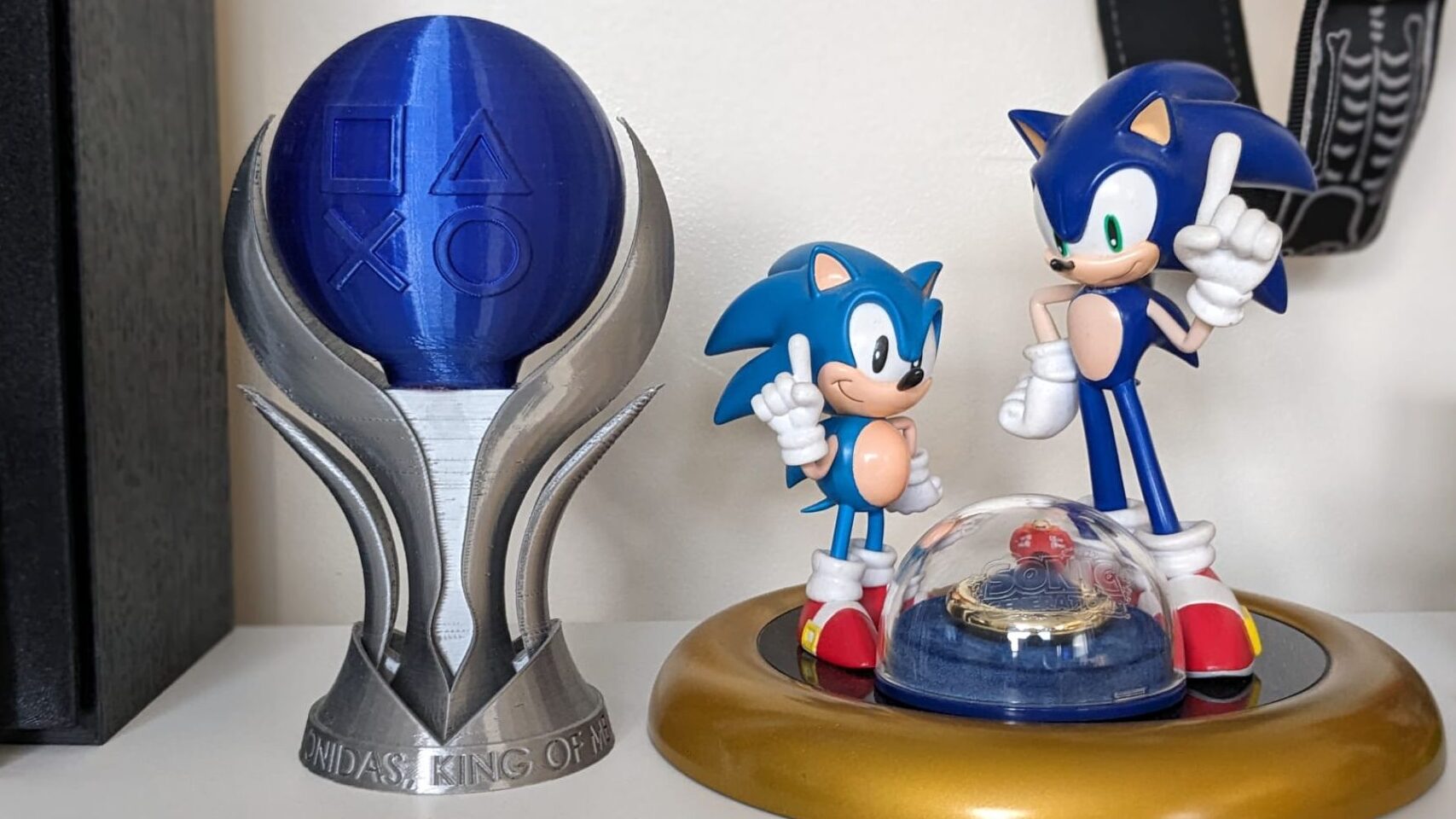 A PLATINUM TROPHY STATUE NEXT TO A STATUE OF SONIC