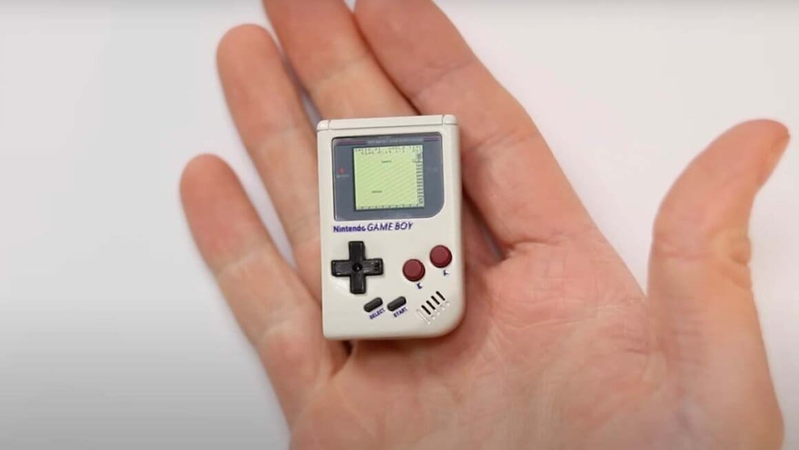 A tiny game boy in the palm of a hand
