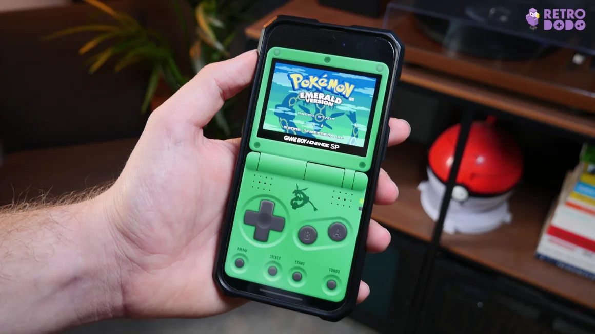Brandon's phone showing a Green GBA SP skin with Pokemon Emerald playing