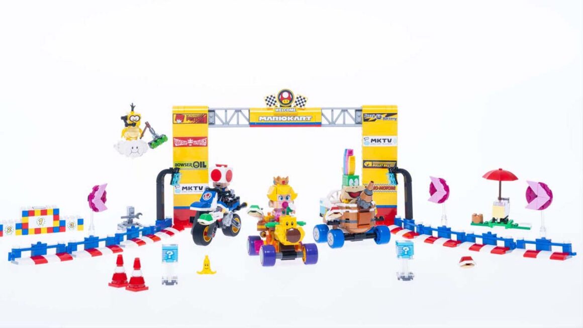 Baby Peach on a Wiggler, Toad on a Bike, and Lemmy on the Landship Lart in a LEGO recreation of the Mario Kart start line 