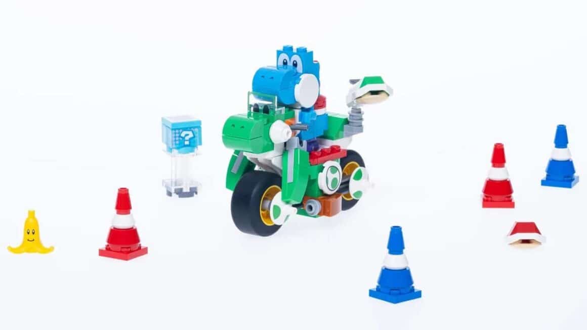 A Lego yoshi on a green bike with cones around him