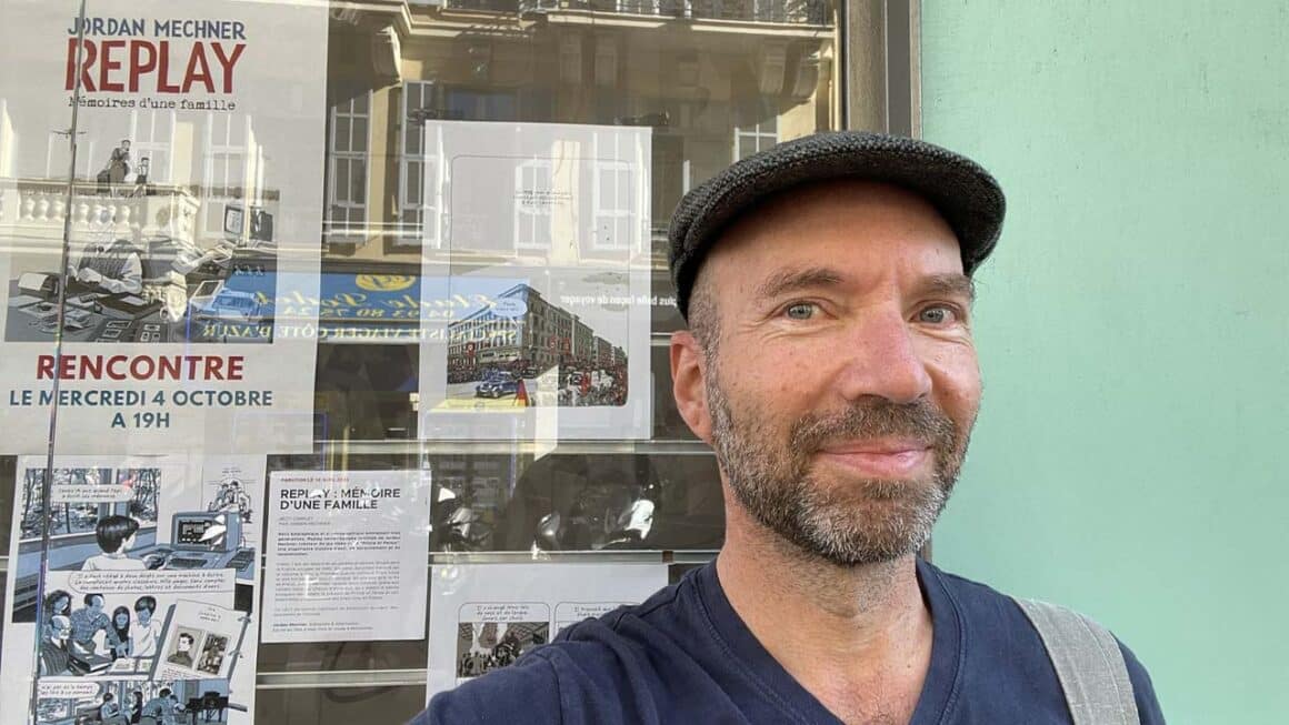 Jordan standing by some posters for his new book Replay